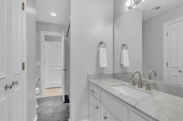 bathroom with tile patterned flooring, vanity, and toilet