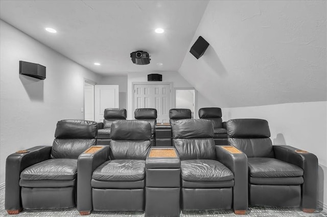 carpeted cinema room featuring vaulted ceiling