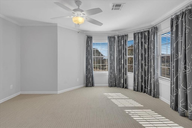 carpeted empty room with ceiling fan, a healthy amount of sunlight, and ornamental molding