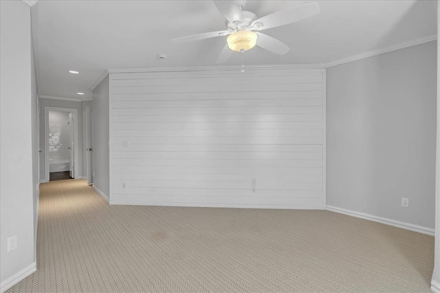 carpeted empty room with ceiling fan and crown molding