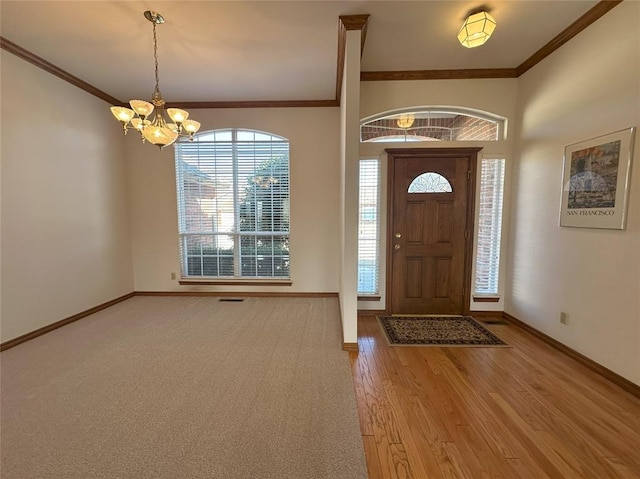 entryway featuring hardwood / wood-style floors, ornamental molding, and an inviting chandelier