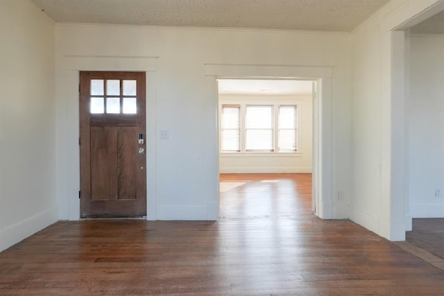 entryway featuring a textured ceiling, crown molding, and dark hardwood / wood-style floors