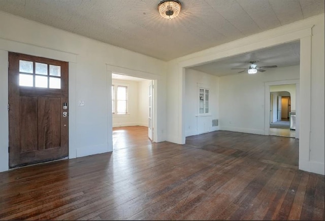 foyer entrance with a textured ceiling, dark hardwood / wood-style flooring, and ceiling fan