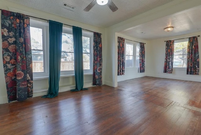 empty room with a textured ceiling, dark hardwood / wood-style floors, and ceiling fan