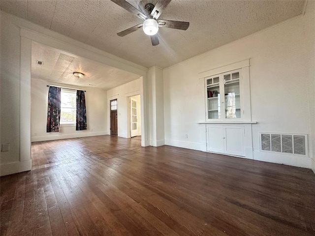 empty room with a textured ceiling, ceiling fan, and dark hardwood / wood-style floors