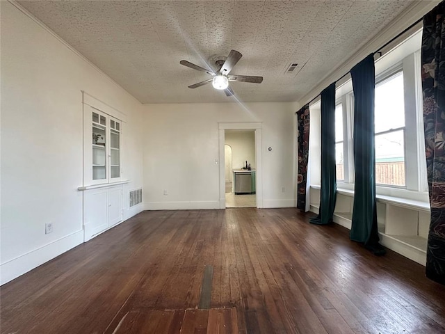 empty room with a textured ceiling, ceiling fan, and dark hardwood / wood-style floors