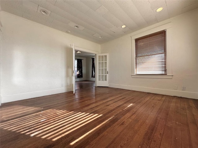 empty room featuring a textured ceiling, dark wood-type flooring, and french doors