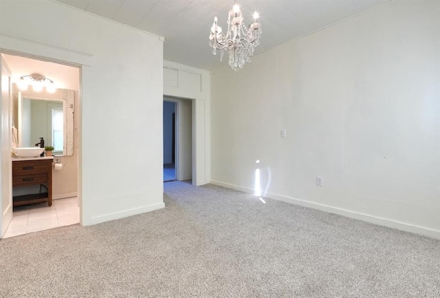 carpeted spare room with a notable chandelier