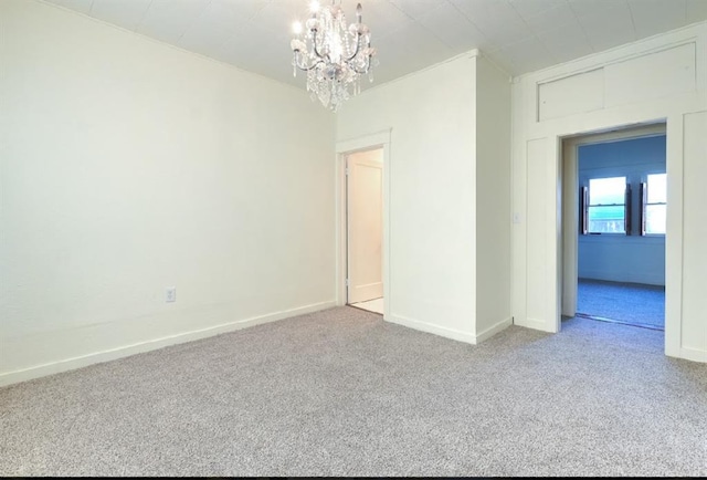 empty room with carpet and an inviting chandelier