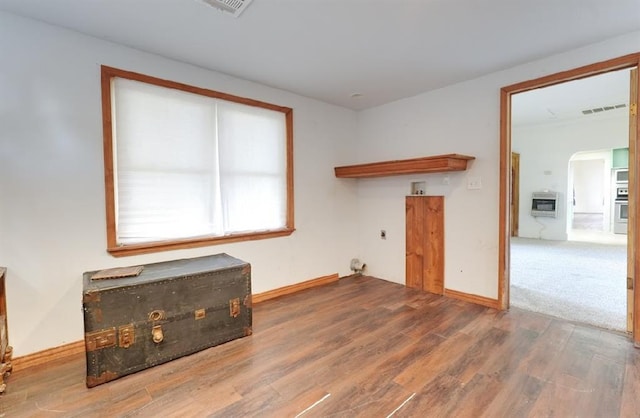 empty room with hardwood / wood-style flooring and heating unit