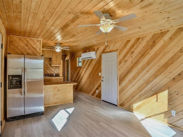 kitchen with stainless steel refrigerator with ice dispenser, wood ceiling, a wall mounted AC, wooden walls, and light hardwood / wood-style flooring