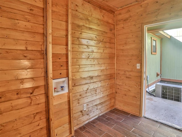 laundry room with wood walls, washer hookup, and dark hardwood / wood-style floors