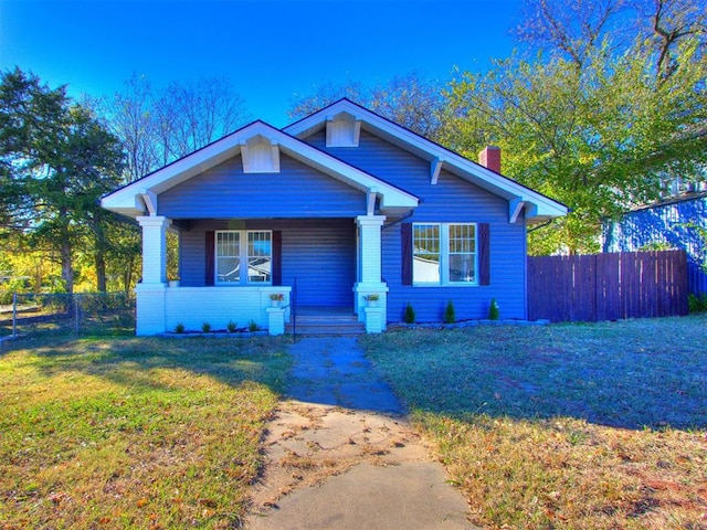 bungalow with covered porch and a front lawn