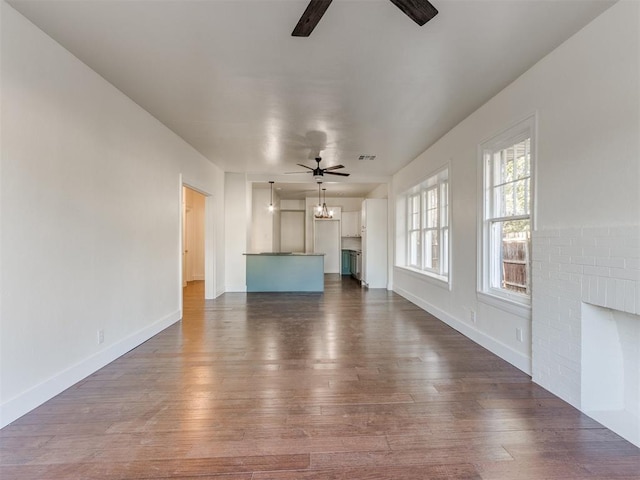 unfurnished living room featuring ceiling fan, a fireplace, and dark hardwood / wood-style floors