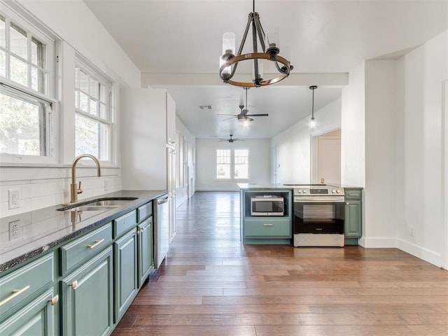 kitchen featuring ceiling fan with notable chandelier, sink, decorative light fixtures, wood-type flooring, and stainless steel appliances