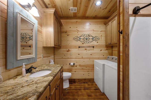 bathroom featuring wooden ceiling, independent washer and dryer, hardwood / wood-style floors, wooden walls, and vanity