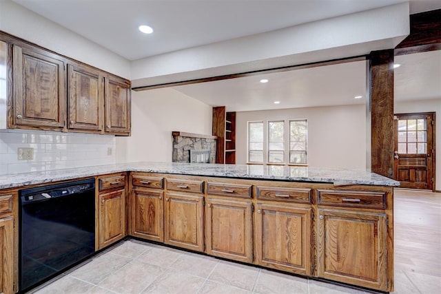 kitchen featuring backsplash, light stone countertops, black dishwasher, light tile patterned floors, and kitchen peninsula