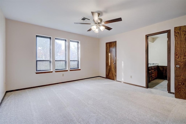 unfurnished bedroom with ensuite bathroom, ceiling fan, and light colored carpet