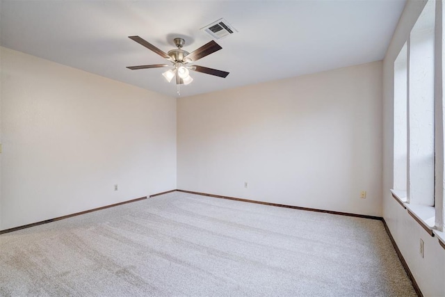 carpeted empty room featuring a wealth of natural light and ceiling fan