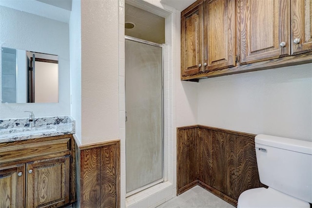 bathroom with a shower with door, vanity, and toilet