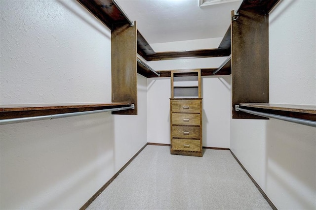 walk in closet featuring light carpet