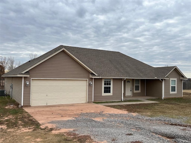 single story home with cooling unit and a garage