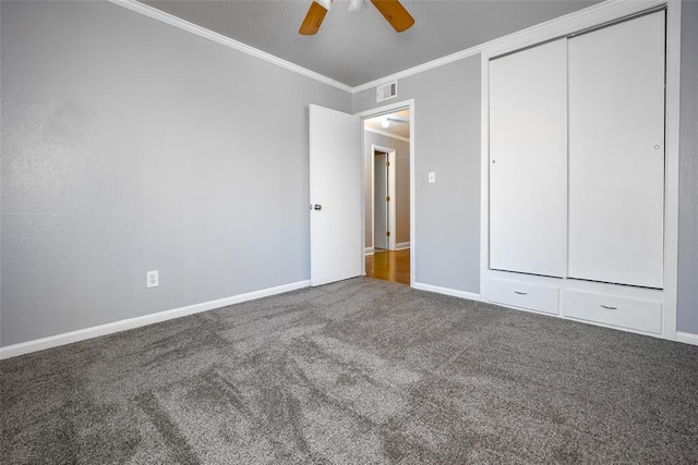 unfurnished bedroom featuring ceiling fan, ornamental molding, a closet, and carpet