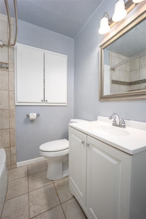 bathroom with toilet, vanity, and ornamental molding