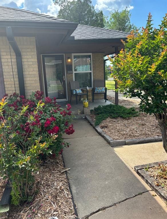 2100 Barclay Rd, Oklahoma City, OK 73120 - entrance to property with covered porch, brick siding, and a shingled roof