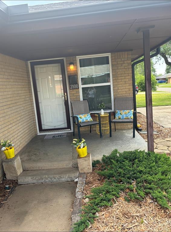 2100 Barclay Rd, Oklahoma City, OK 73120 - doorway to property with brick siding and a porch