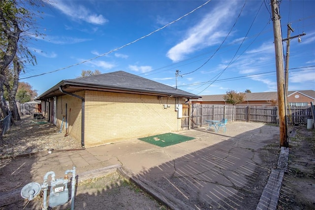 2100 Barclay Rd, Oklahoma City, OK 73120 - rear view of house with brick siding, a fenced backyard, a patio, and roof with shingles