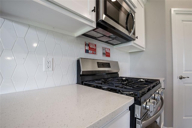 kitchen with white cabinetry, appliances with stainless steel finishes, and tasteful backsplash