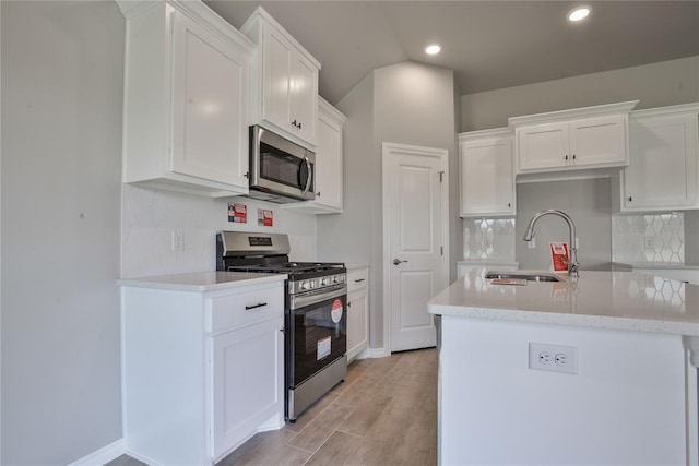 kitchen with white cabinetry, sink, light hardwood / wood-style floors, and appliances with stainless steel finishes