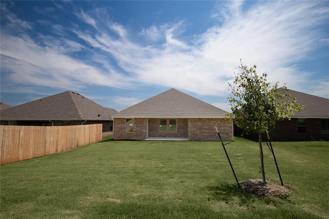 back of property with a lawn and a patio area