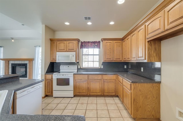 kitchen featuring backsplash, white appliances, a fireplace, and light tile patterned floors