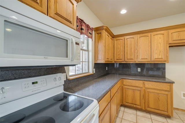 kitchen featuring decorative backsplash, white appliances, and light tile patterned flooring