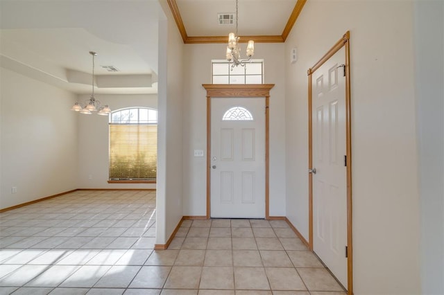 foyer entrance with light tile patterned floors, ornamental molding, and a notable chandelier