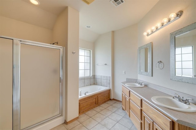 bathroom featuring independent shower and bath, tile patterned floors, vaulted ceiling, and a healthy amount of sunlight