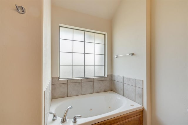 bathroom featuring a bathtub, a healthy amount of sunlight, and vaulted ceiling