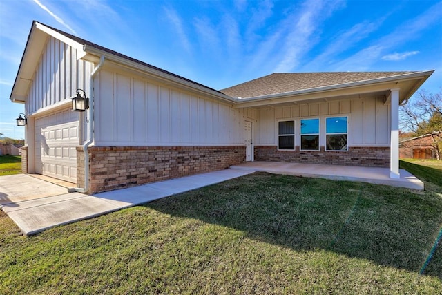 back of house with a yard and a garage