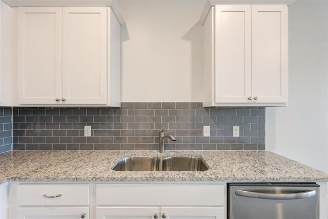 kitchen with light stone countertops, tasteful backsplash, sink, dishwasher, and white cabinetry