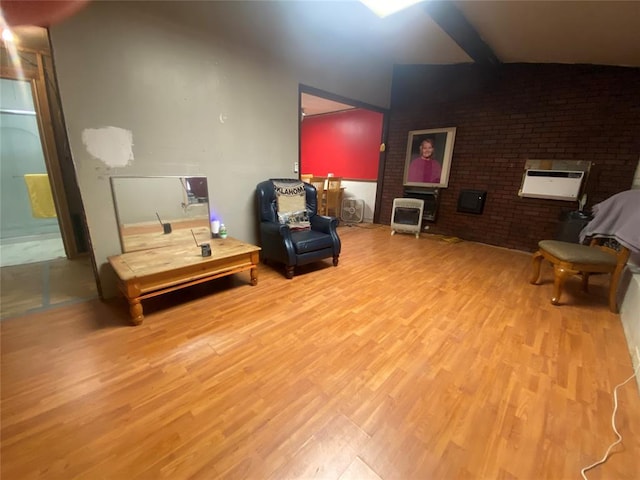 living area with light hardwood / wood-style floors, a wall unit AC, and brick wall