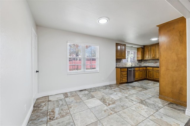 kitchen featuring tasteful backsplash, stainless steel dishwasher, and sink