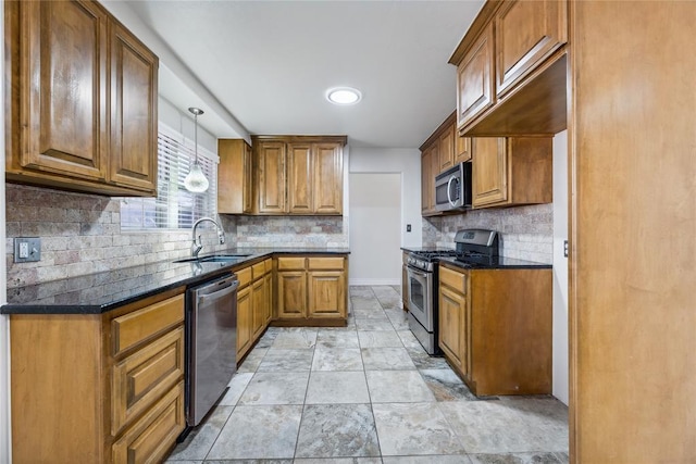 kitchen with backsplash, hanging light fixtures, sink, and appliances with stainless steel finishes