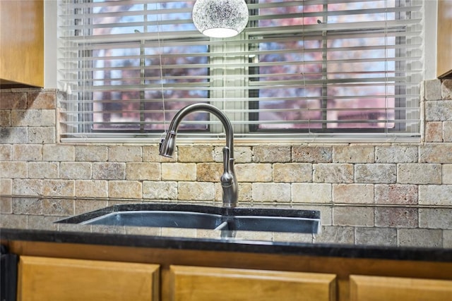 room details with tasteful backsplash, dark stone countertops, and sink