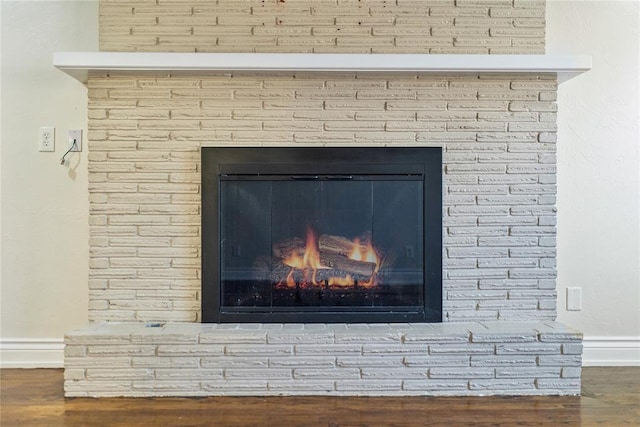 details with hardwood / wood-style floors and a brick fireplace