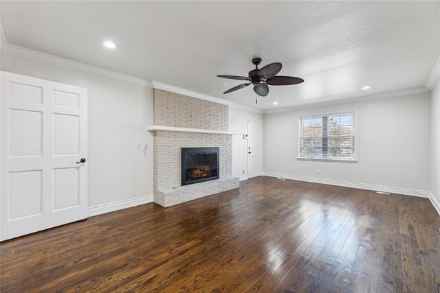 unfurnished living room with a fireplace, ceiling fan, dark hardwood / wood-style flooring, and crown molding