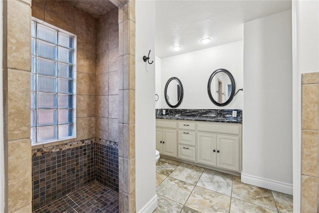 bathroom with tiled shower and vanity