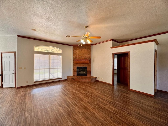 unfurnished living room with ceiling fan, ornamental molding, a fireplace, a textured ceiling, and dark hardwood / wood-style flooring