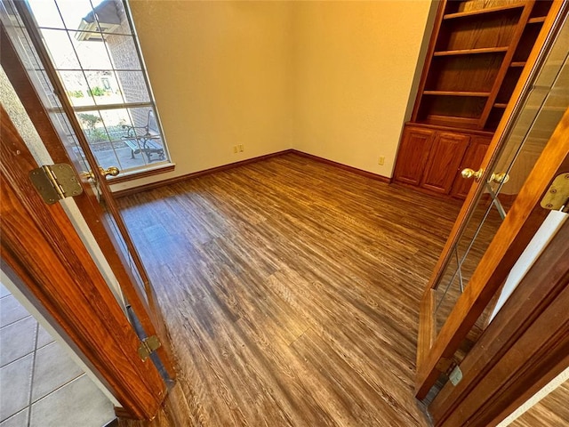 spare room with french doors and hardwood / wood-style flooring